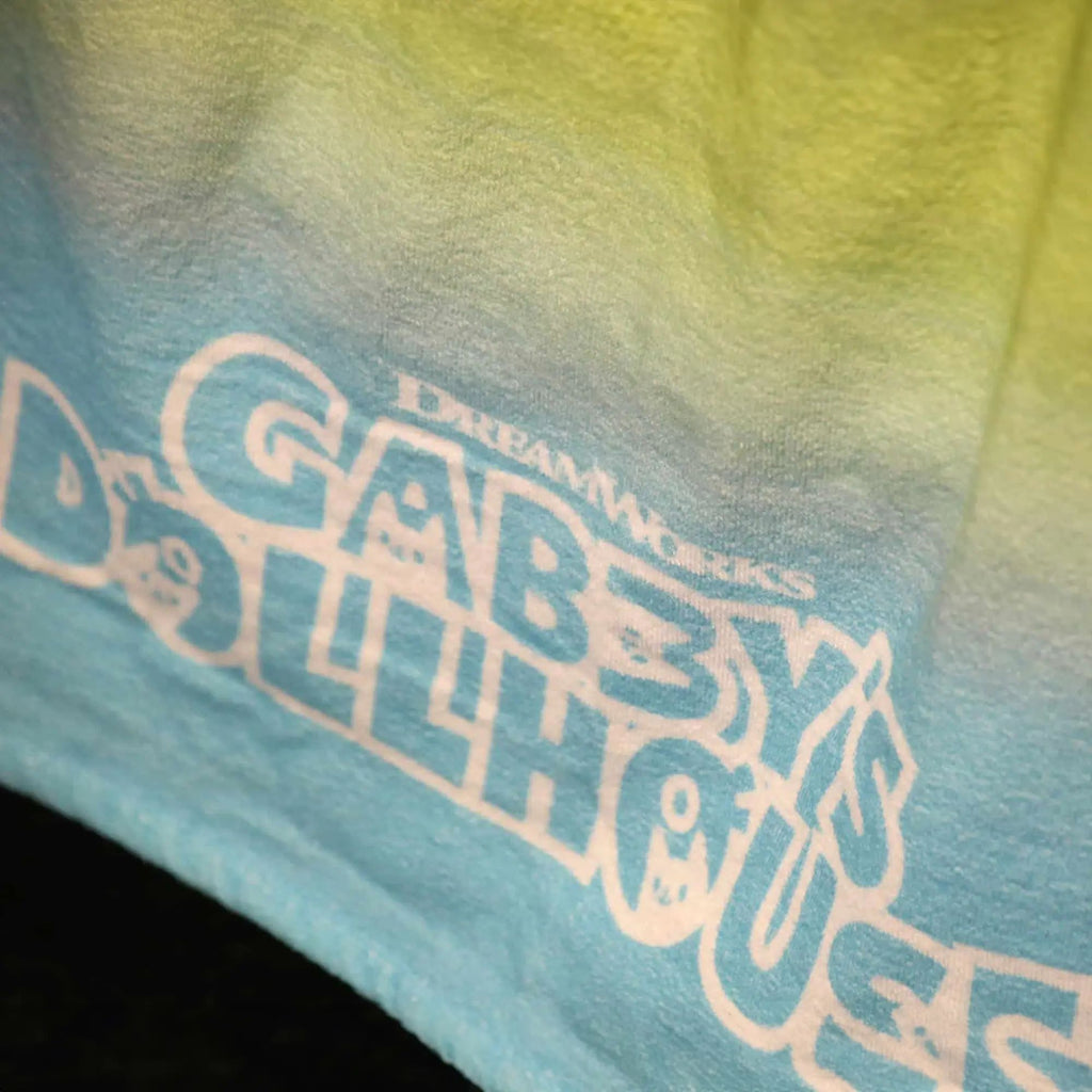 Schriftzug „Gabby's Dollhouse“ auf dem Badetuch in Nahaufnahme