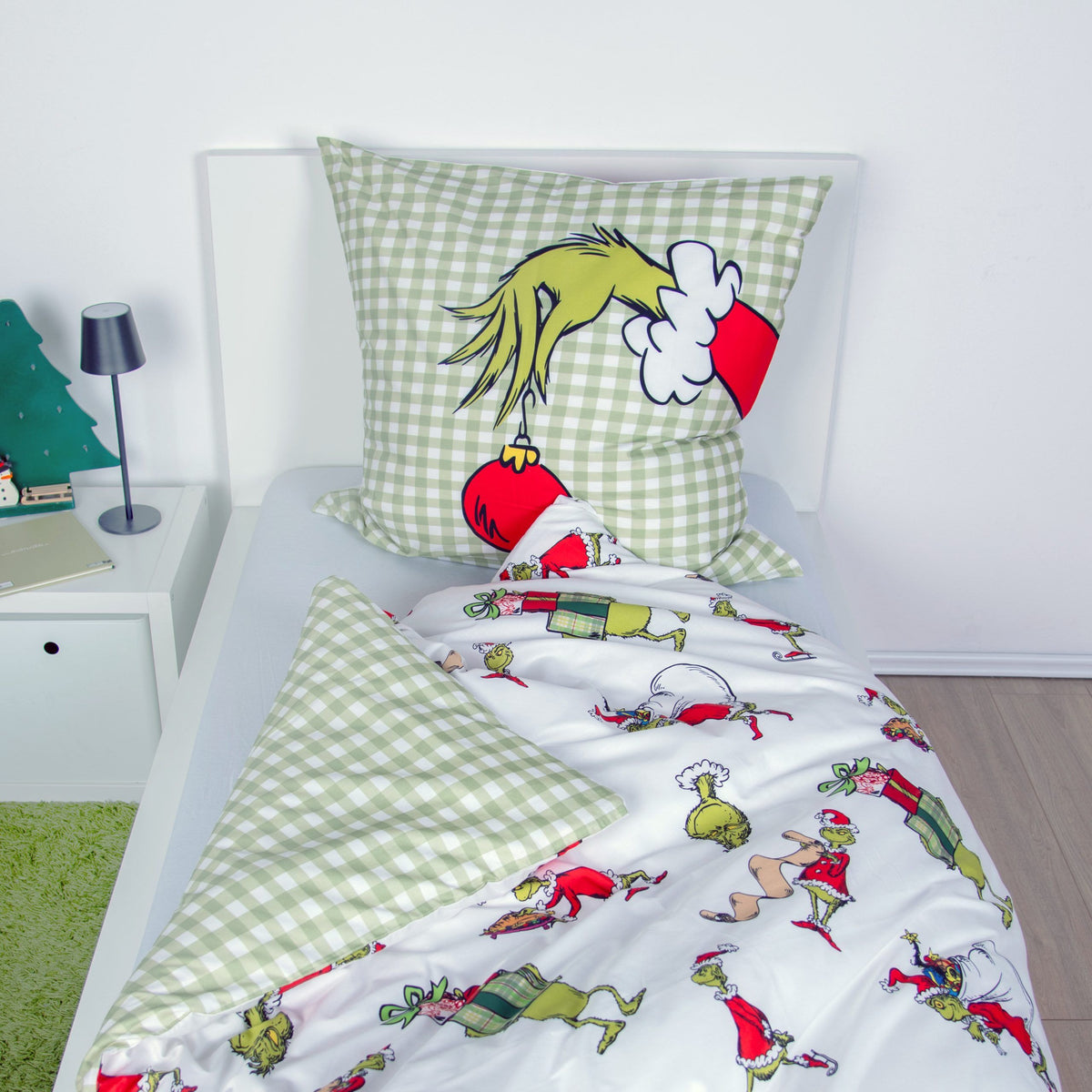Wendeseite der Grinch Winterbettwäsche: grün-weißes Karo mit Grinch-Hand und roter Christbaumkugel