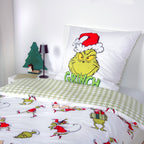 Grinch Winterbettwäsche ‘Merry Grinchmas’ mit umgeschlagener Karo-Wendeseite auf dem Bett