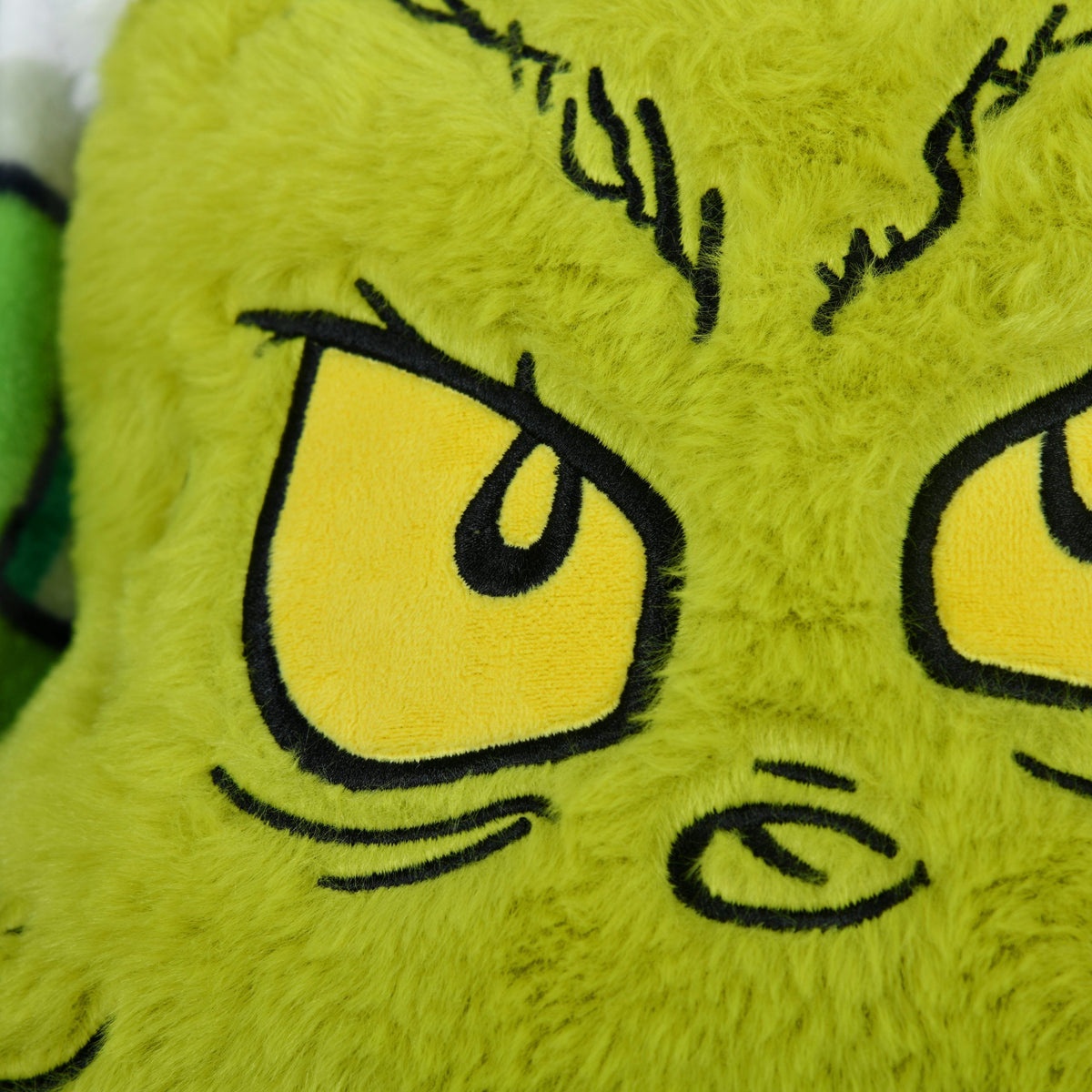 Grinch Formkissen ‘Merry Grinchmas’, Nahaufnahme der gestickten Augen und des Flausch-Bezugs