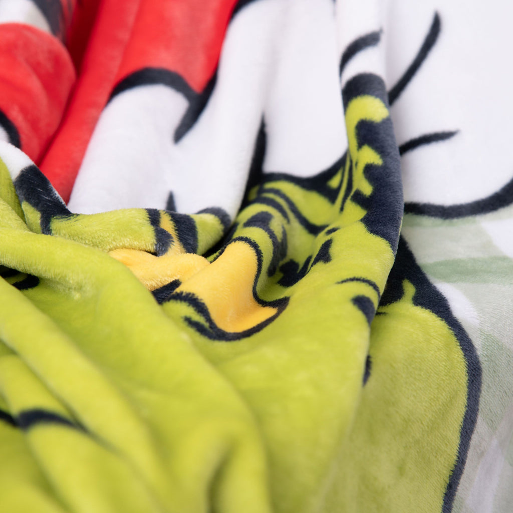 Nahaufnahme des Wellsoft-Flauschs der Grinch Kuscheldecke mit Grinch-Augen