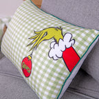 Rückseite des Grinch Kuschelkissens: grün-weißes Karo mit Grinch-Hand und roter Kugel, grüner Kederrand