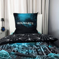 Kissen mit „Hogwarts“-Schriftzug auf türkisem Nebel und Wendeseite mit Liniennetz auf einem Bett