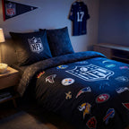 NFL Bettwäsche ‘All Teams’ auf einem Bett, schräge Ansicht mit Kissen