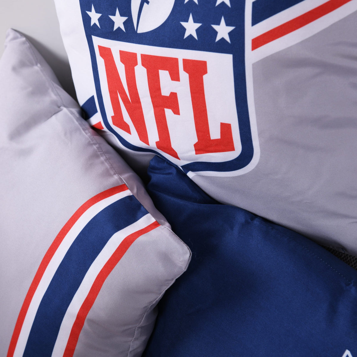 Nahaufnahme der NFL-Kissen mit Shield-Logo und Streifen in Rot, Weiß und Blau
