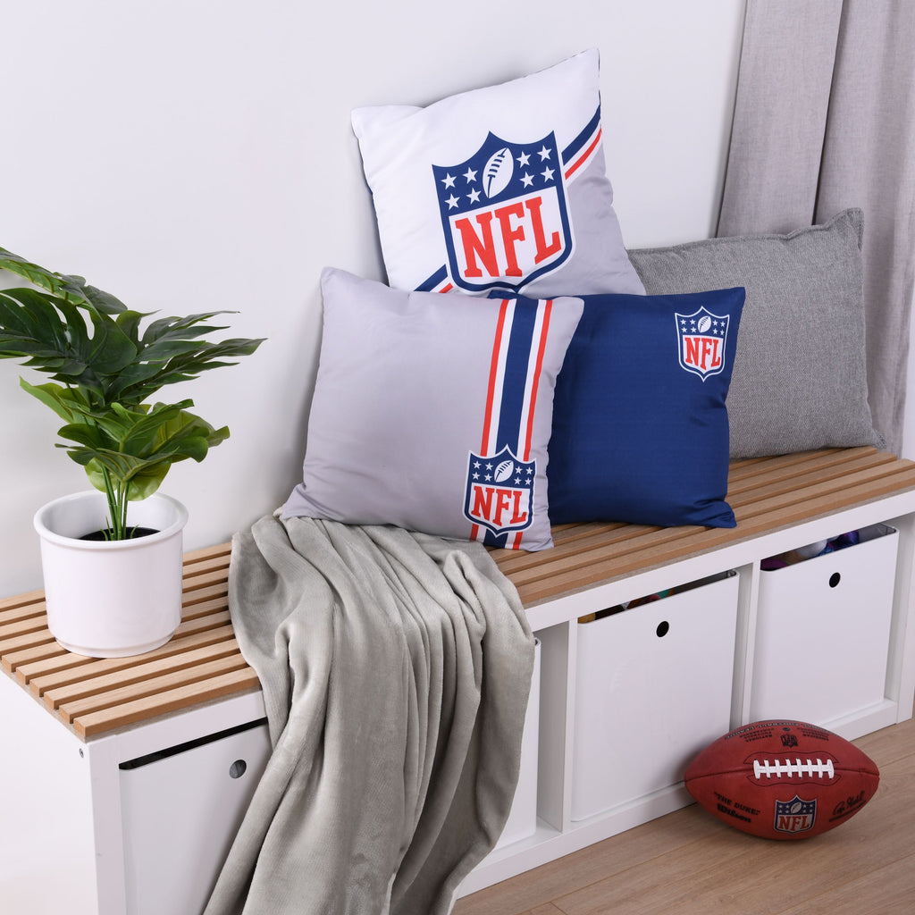 NFL Dekokissen-Set ‘Classic’ auf einer Holzbank mit Decke und Football, Vorderseiten der drei Kissen