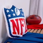 NFL Formkissen ‘Shield’ auf einer Holzbank, dahinter ein Football