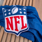 NFL Formkissen ‘Shield’ auf einer blauen Decke