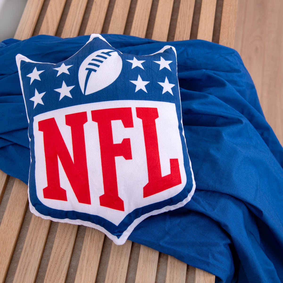 NFL Formkissen ‘Shield’ auf einer blauen Decke