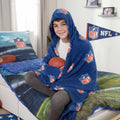 Junge mit der NFL Kapuzendecke ‘Classic’ und einem Football auf dem Bett