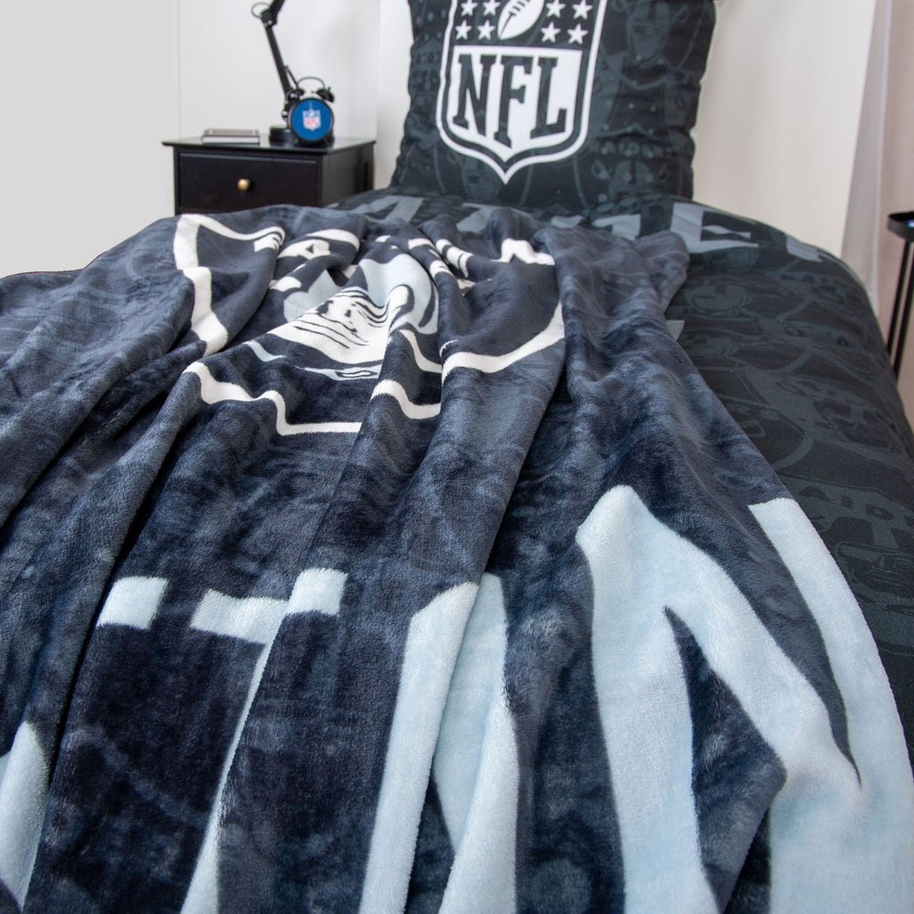 Kuscheldecke ‘Raiders’ locker auf einem Bett mit NFL-Kissen