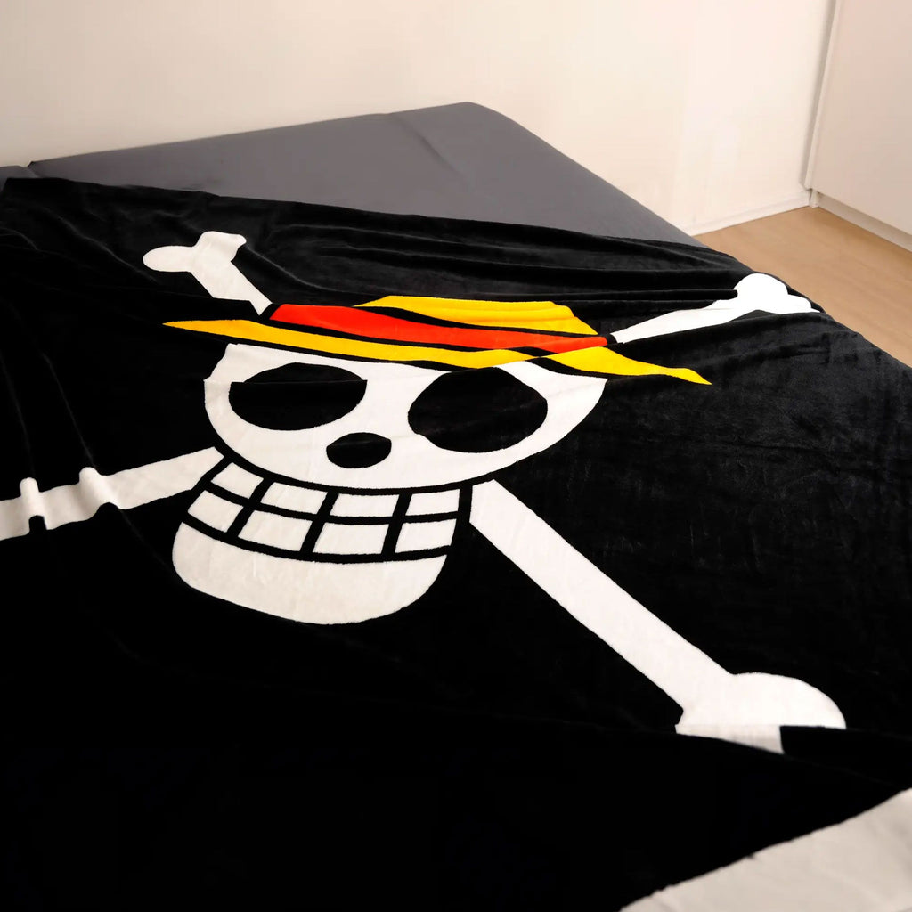 One Piece Kuscheldecke ‘Skull’ auf einem Bett