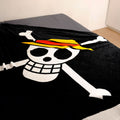 One Piece Kuscheldecke ‘Skull’ auf einem Bett