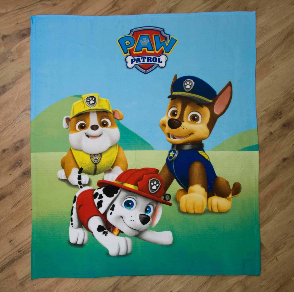 Paw Patrol Fleecedecke ‘Classic’ ausgebreitet auf einem Holzboden