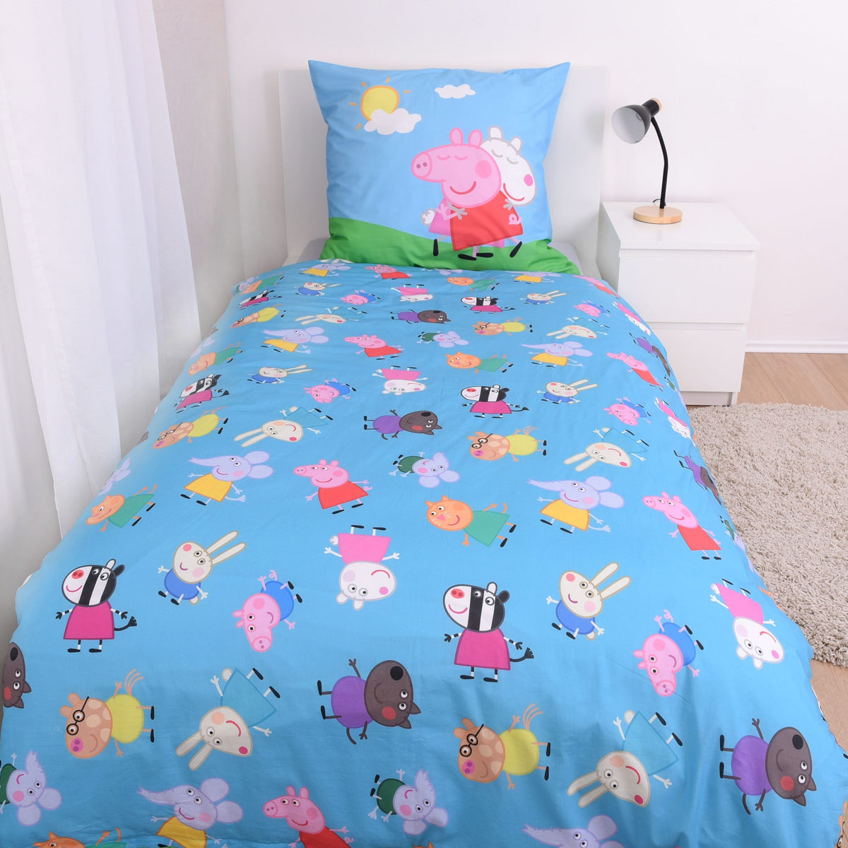 Blaue Wendeseite der Peppa Wutz Bettwäsche ‘Friends’ mit kleinen Figuren auf einem Bett