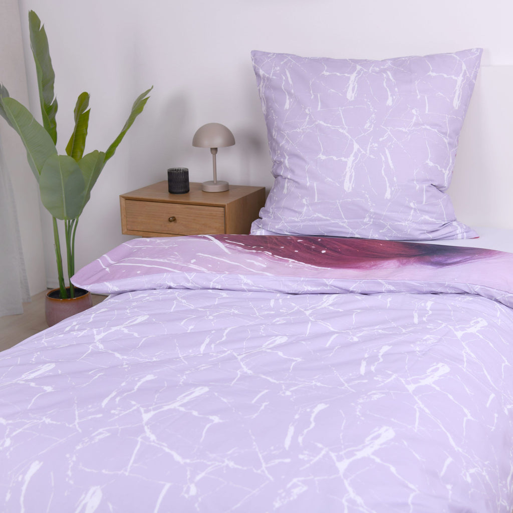 Bett mit der fliederfarbenen Marmor-Wendeseite und passendem Kissen