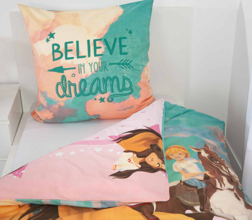 Kissen mit Schriftzug Believe in your dreams und rosa Wendeseite der Spirit Bettwäsche