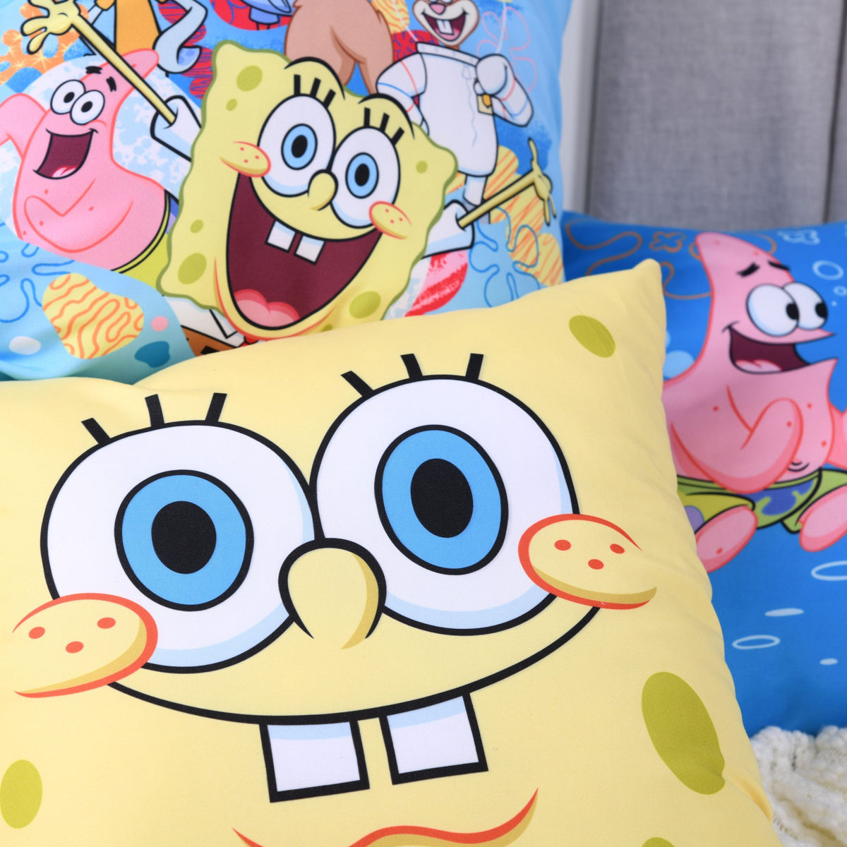 SpongeBobs Gesicht vor dem Kissen mit der Clique aus Bikini Bottom