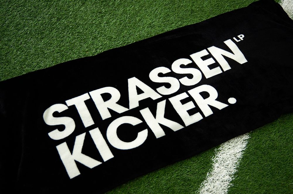 STRASSENKICKER Kuscheldecke auf einem Kunstrasenplatz