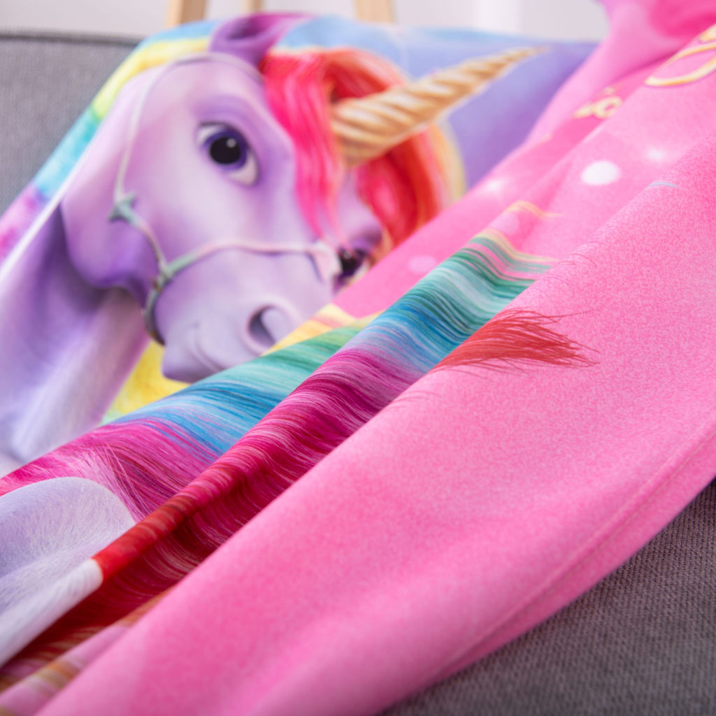 Kopf des Einhorns auf der Fleecedecke ‘Magic’ auf dem Sofa