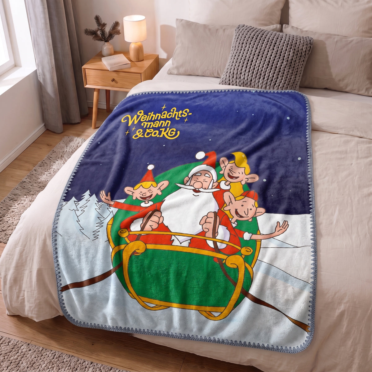 Kuscheldecke ‘Nordpol-Helden’ mit Blankett-Stich auf einem Bett im hellen Schlafzimmer