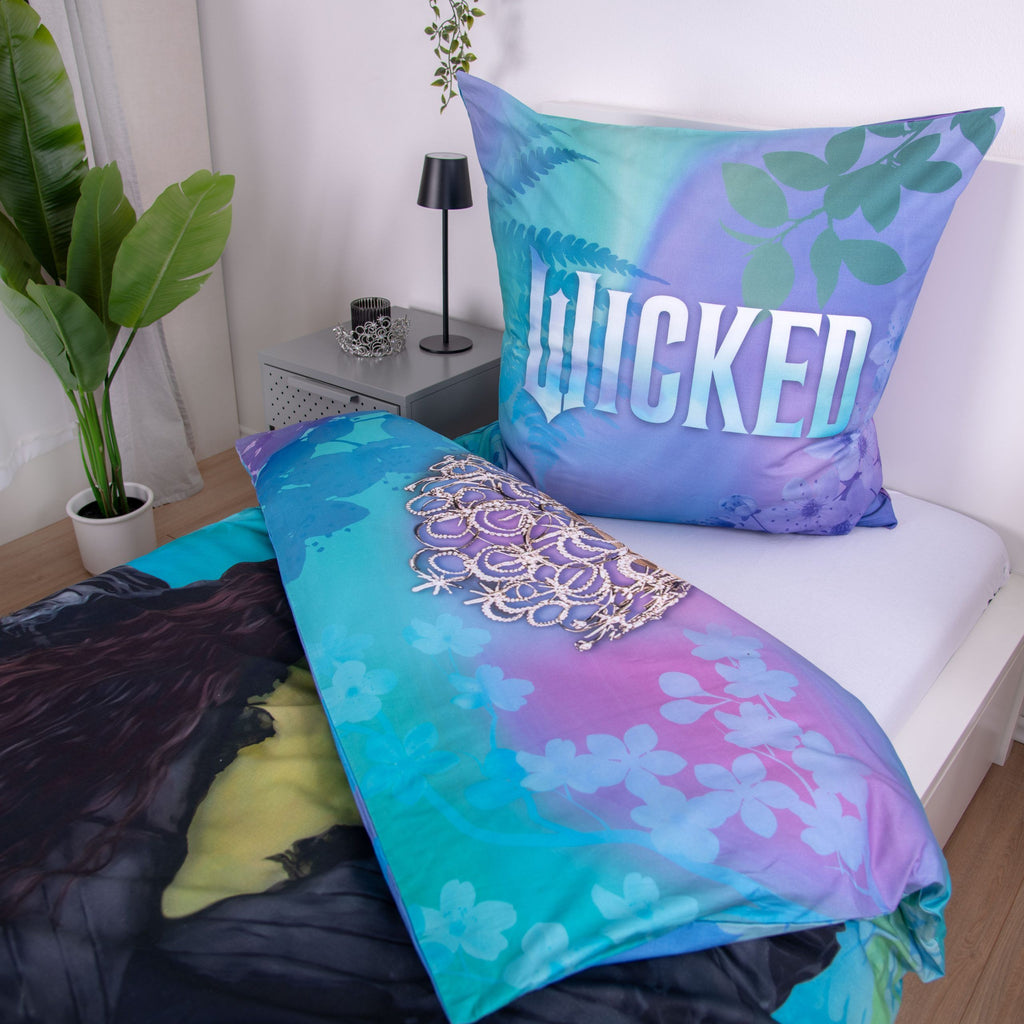 Kissen mit Wicked-Schriftzug und aufgeschlagener Bettbezug der Bettwäsche ‘Twilight Magic’