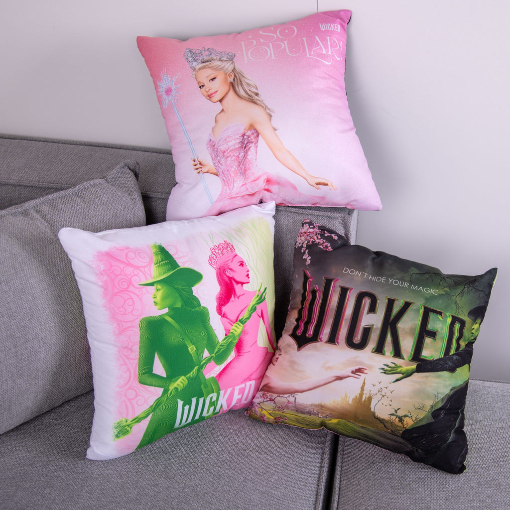 Kissen mit Glinda, den Silhouetten und dem Filmplakat auf dem grauen Sofa