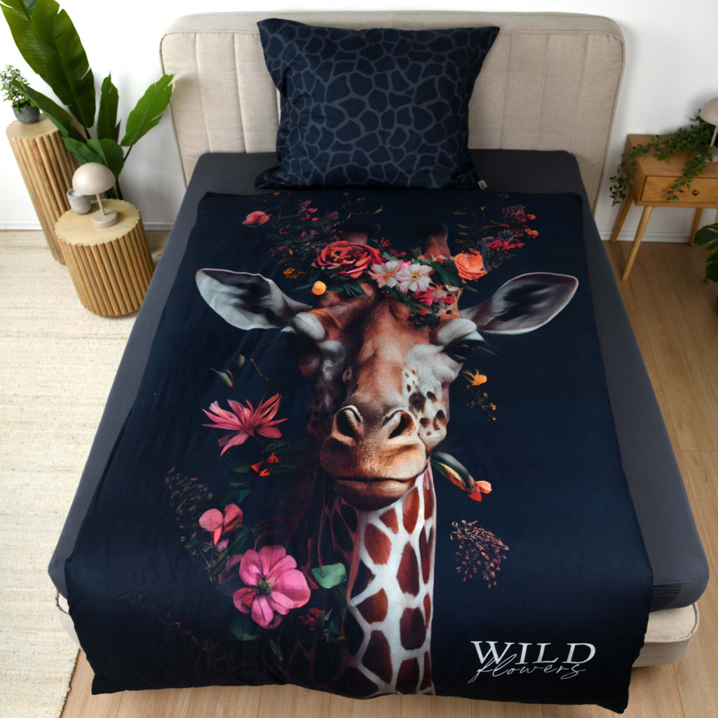 Wild Flowers Bettwäsche ‘Giraffe’ auf einem Bett, Giraffe mit Blumenkranz auf Dunkelblau