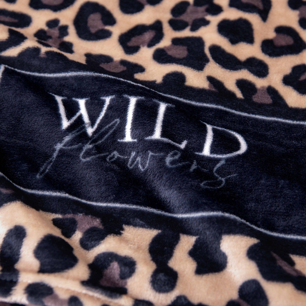 Aufgedrucktes Logo „WILD flowers“ auf der Kuscheldecke ‘Leo’