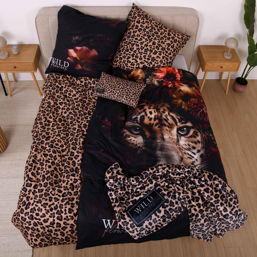 Kuscheldecke ‘Leo’ auf einem Bett mit dem Wild Flowers Bettwäsche-Set ‘Leopard’