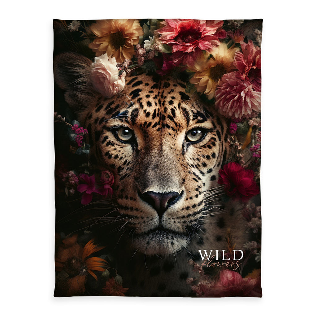Wild Flowers Kuscheldecke ‘Leopard’ 150 x 200 cm: Leopard zwischen roten und rosa Blüten auf Schwarz mit Schriftzug „WILD flowers“