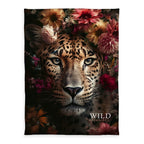 Wild Flowers Kuscheldecke ‘Leopard’ 150 x 200 cm: Leopard zwischen roten und rosa Blüten auf Schwarz mit Schriftzug „WILD flowers“