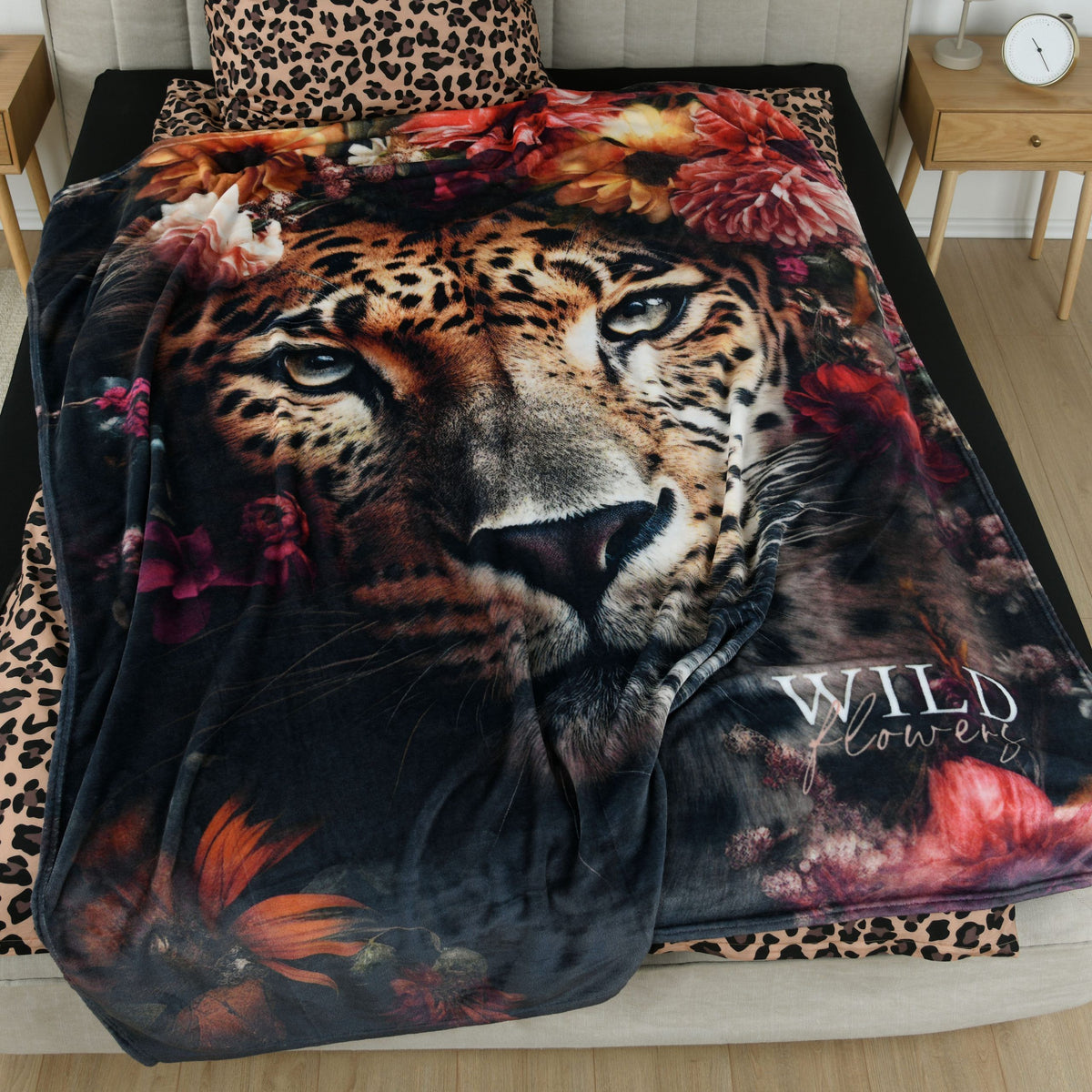 Kuscheldecke ‘Leopard’ auf einem Bett mit Bettwäsche im Leopardenmuster