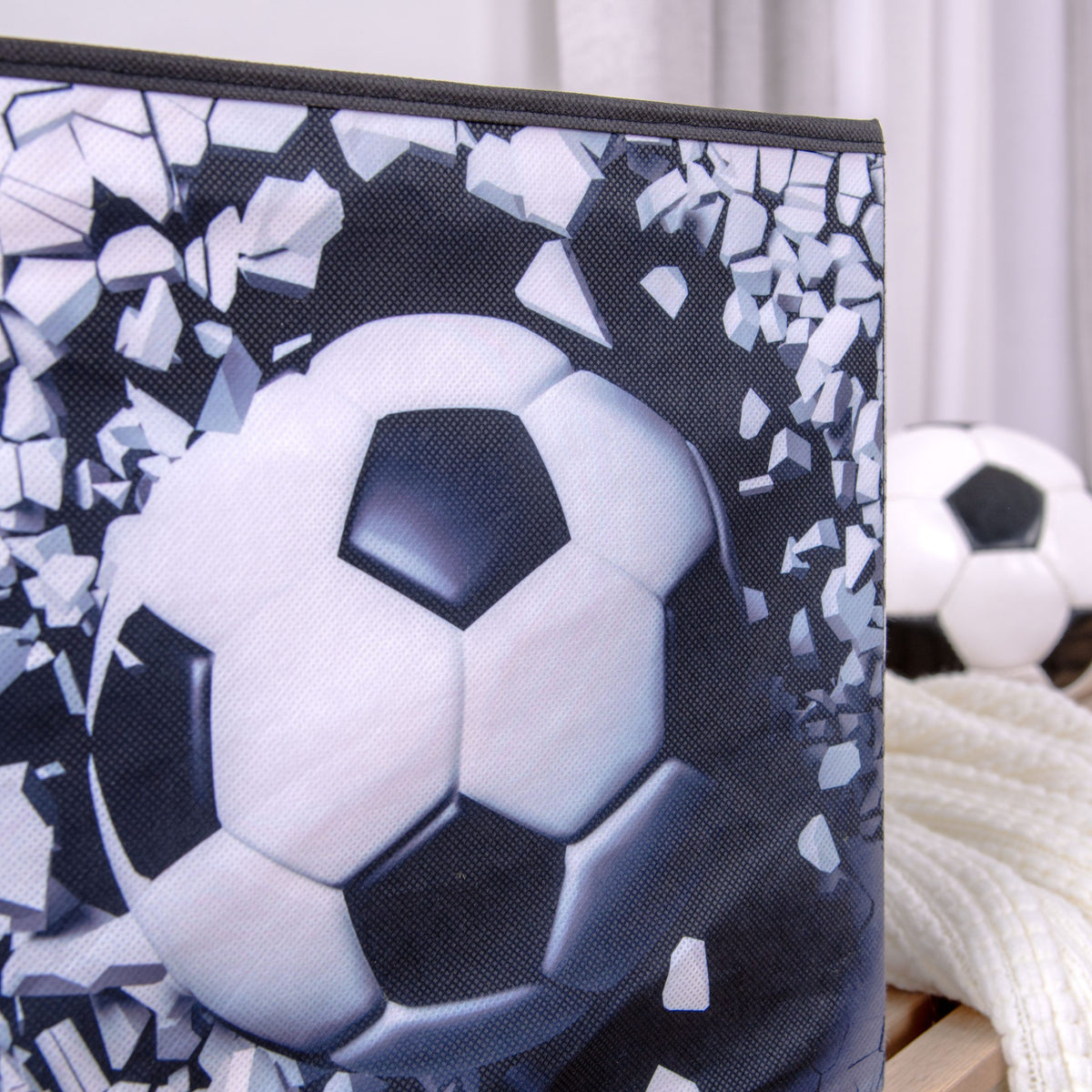 Nahaufnahme des Fußballs, der auf der Aufbewahrungsbox durch die Wand bricht