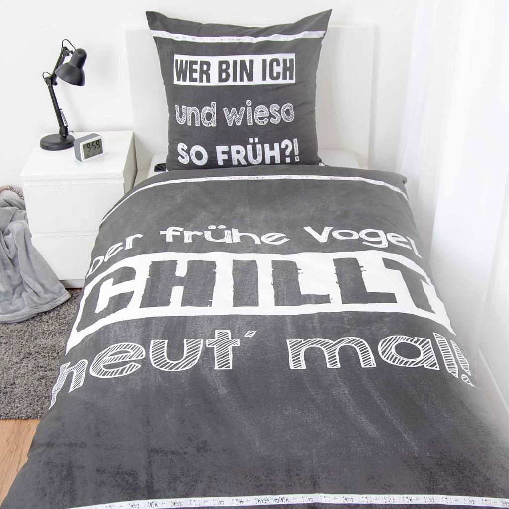 Bettwäsche ‘Der frühe Vogel’ auf einem Einzelbett, Spruch auf Tafelgrund