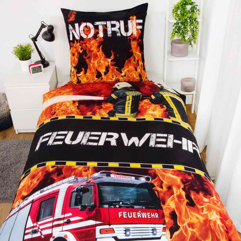 Young Collection Bettwäsche ‘Feuerwehr’ auf einem Bett im Kinderzimmer, Motivseite mit Löschfahrzeug