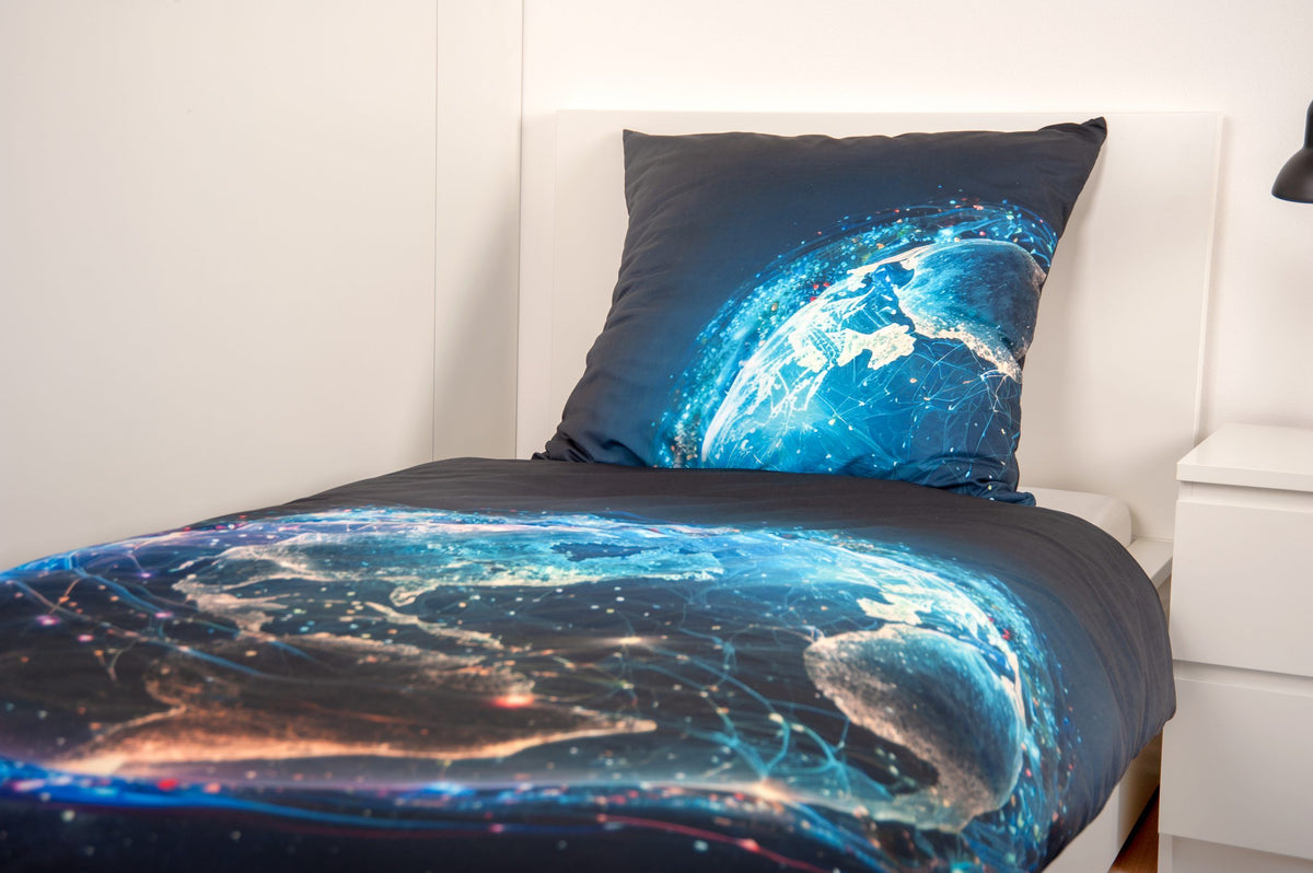 Bettwäsche ‘Weltkugel’ seitlich auf einem Bett mit leuchtenden Kontinenten