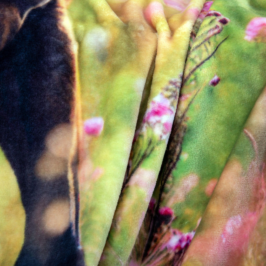 Nahaufnahme von Blüten und Gras auf der Kuscheldecke ‘Pferdeglück’